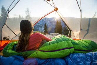 Femme admirant la vue de Half Dome depuis sa tente en montagne