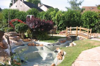 Pont en bois décoratif au-dessus d'un bassin de jardin