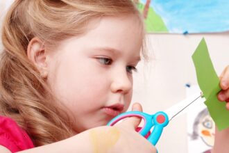 Enfant en train de découper des papiers pour une activité créative
