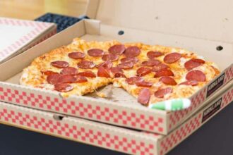 Personne savourant une pizza avec des amis autour d'une table